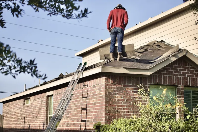 Professional roofer working on a residential roof in Franjo